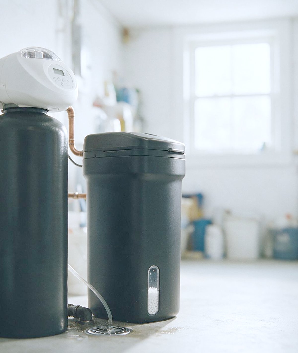 A softener resin tank and brine tank installed in a basement corner
