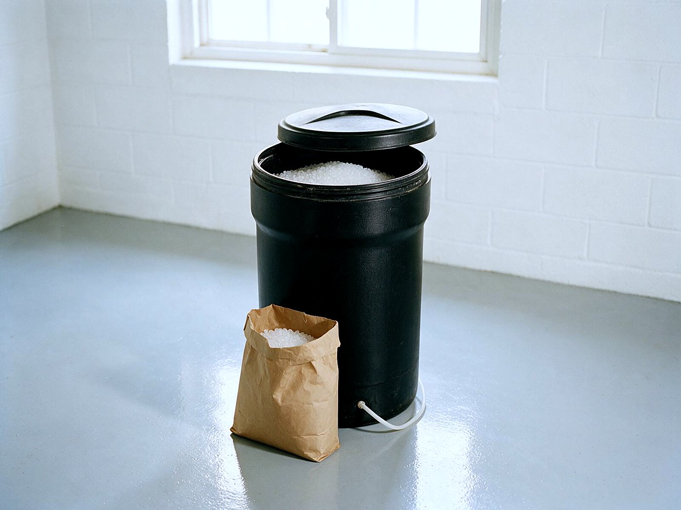 A bag of softener salt beside an open brine tank